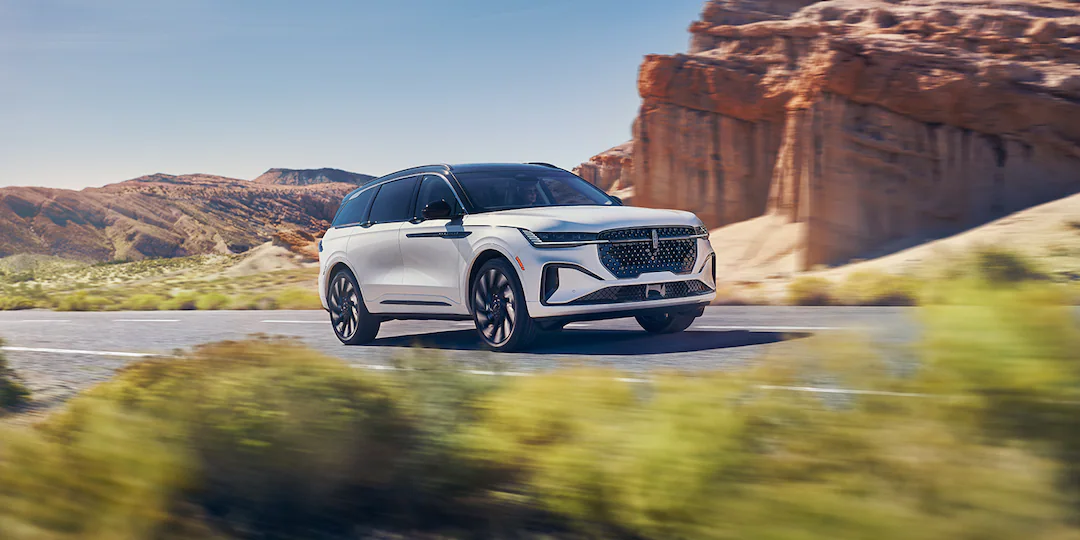 Lincoln Nautilus™ SUV driving on road next to rock structure