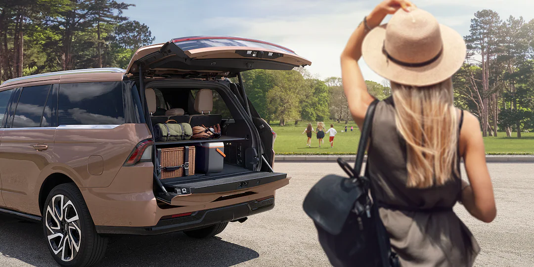 Person looking at kids running in the distance with Lincoln® Navigator trunk open next to her
