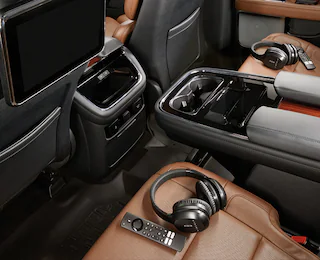 Backseat of Lincoln SUV with headphones and entertainment system