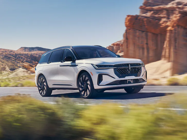 Lincoln Nautilus™ SUV driving on road next to rock structure