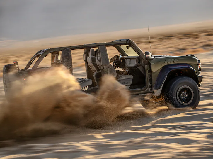 A 2025 Ford Bronco® with roof and doors removed being driven through sand