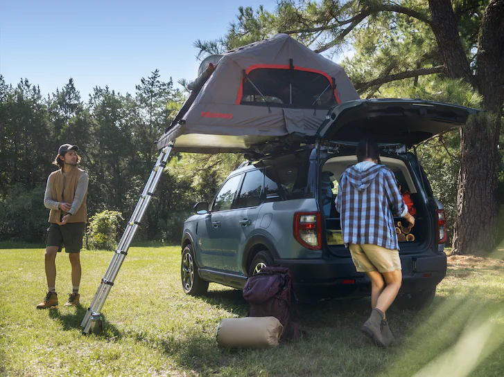 A 2024 Bronco Sport® SUV with roof tent and people camping
