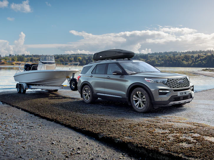 An Explorer® SUV pulling a boat out of a lake