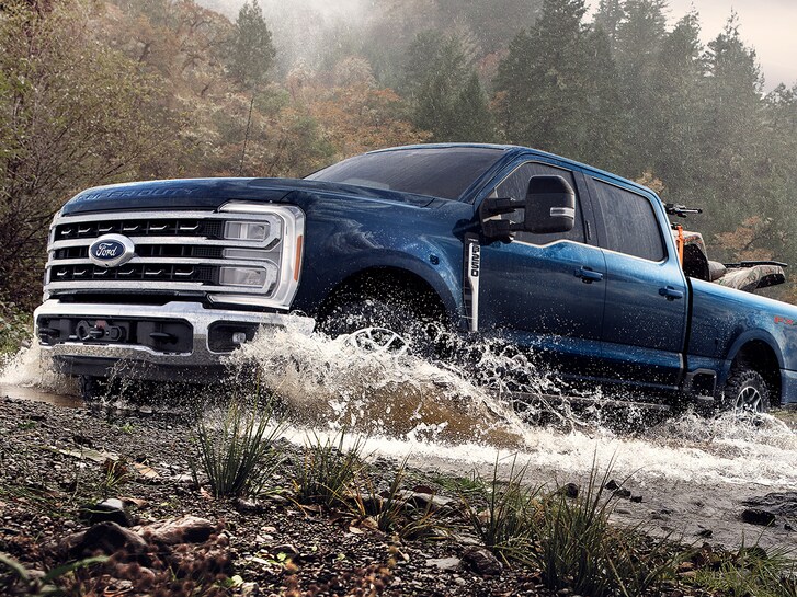 Closeup of a Ford F-250 Super Duty® Tremor splashing through a shallow creek