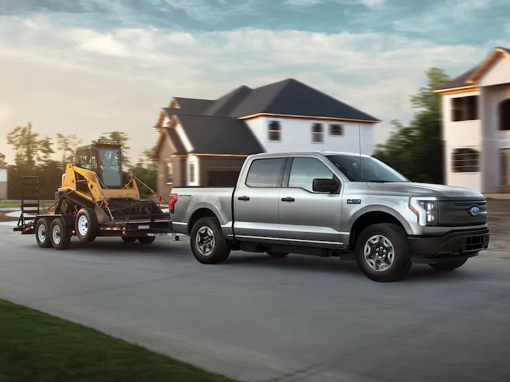 A Ford F-150 Super Duty® Pro Crew Cab towing a large loader