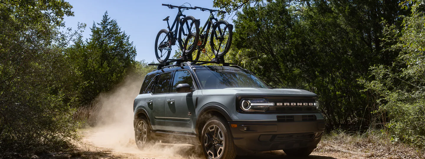 Bronco Sport® with bikes on roof driving on dirt road