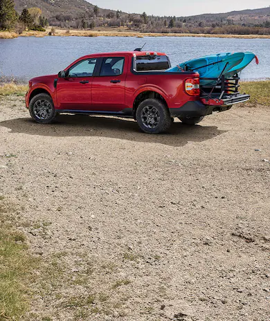 2026 Ford Maverick® Lariat® parked near a lake with two kayaks in the bed