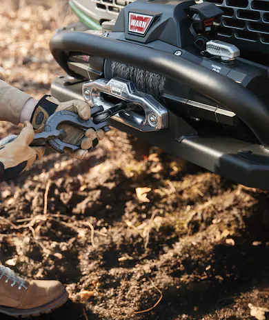 Gloved hands connecting a shackle to Bronco Winch Kit