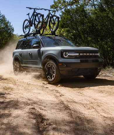Bronco Sport® with bikes on roof driving on dirt road
