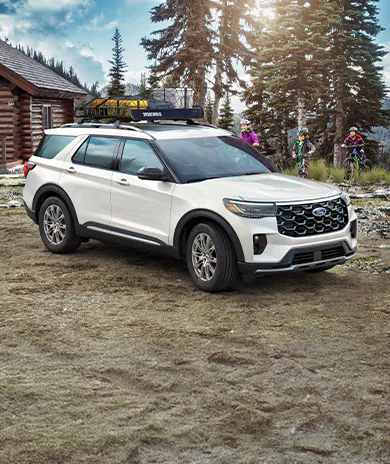 A 2025 Ford Explorer® SUV parked near a camper with people biking