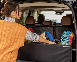 A woman reaching for something in back of a 2025 Ford Bronco