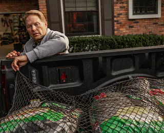 exterior shot of a man securing bed cargo with netting
