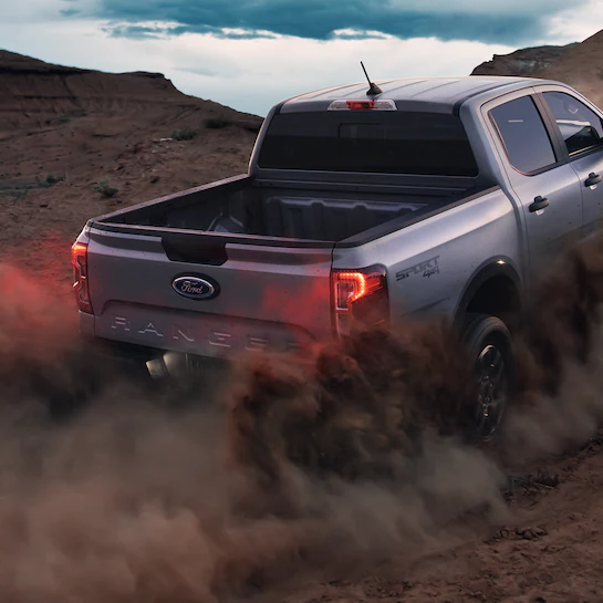 A 2025 Ford Ranger® Sport at dusk kicking up dust