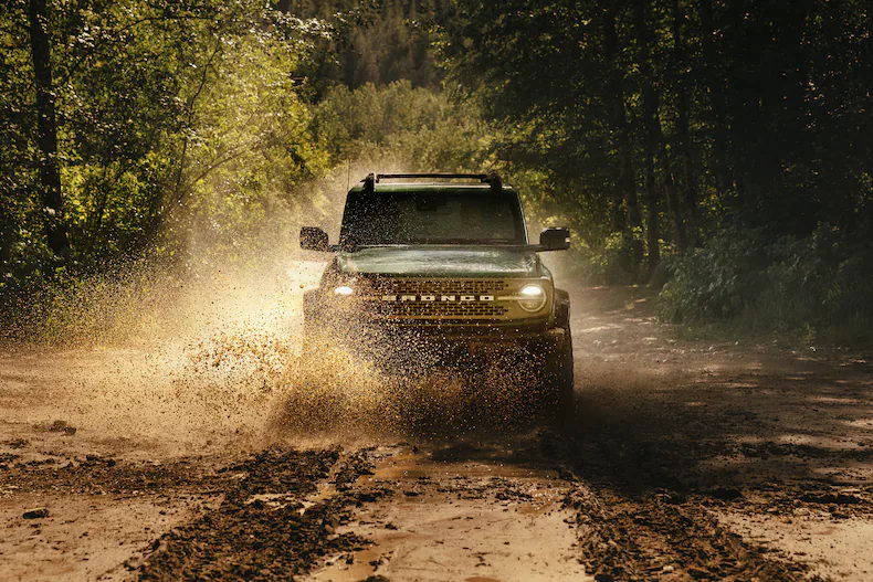 Head-on shot of a 2025 Ford Bronco® splashing through a puddle