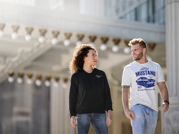 Two people walking dressed with Ford merchandising