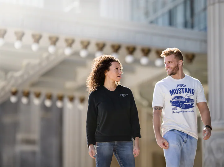 Two people walking dressed with Ford merchandising
