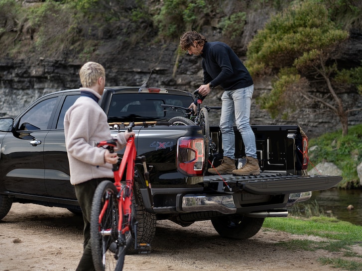 Two people loading bicycles into the bed of a 2025 Ford Ranger®