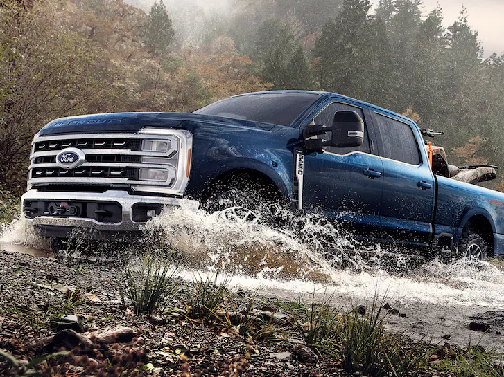 Closeup of a Ford F-250 Super Duty® Tremor splashing through a shallow creek